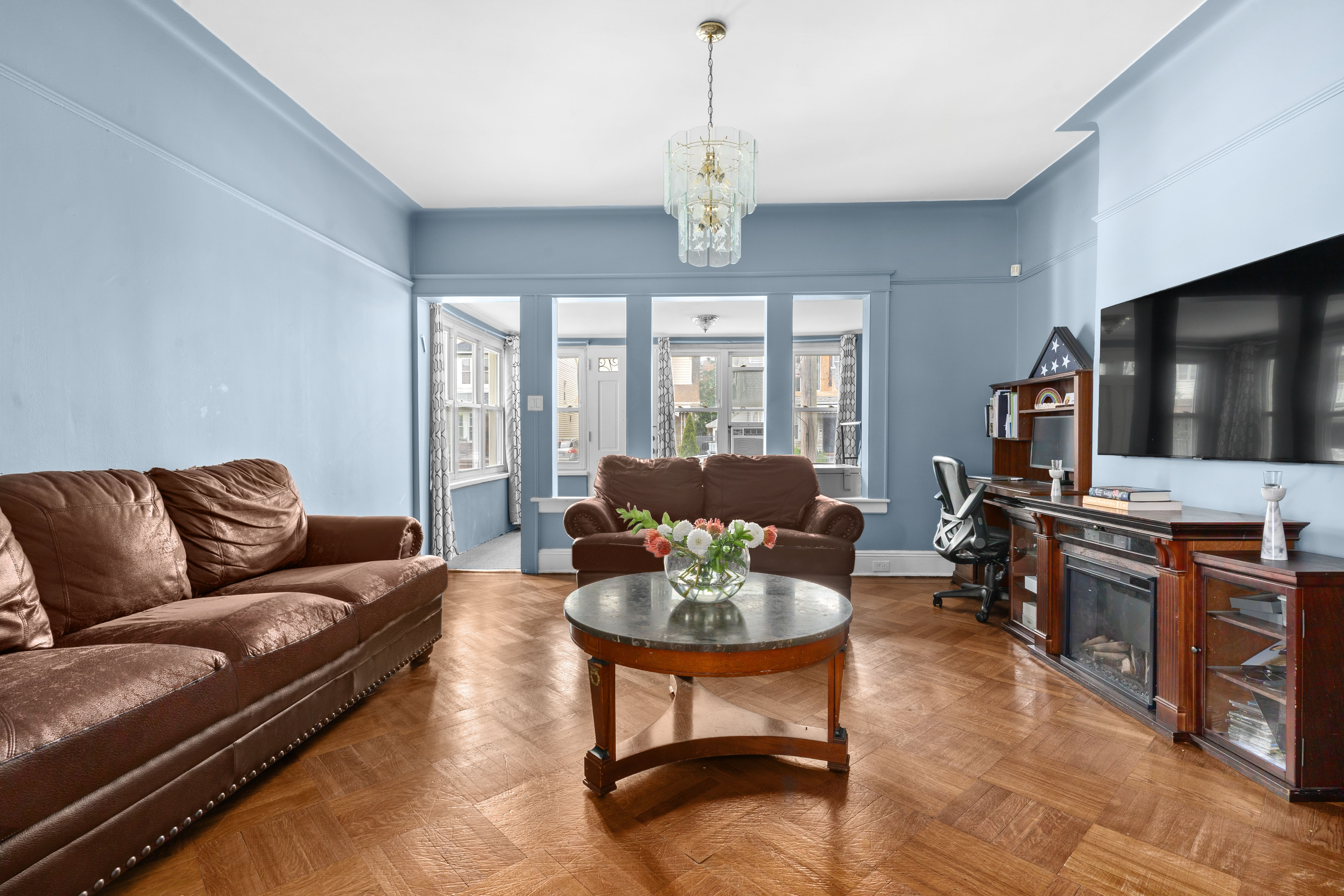 a living room with furniture a flat screen tv and large window