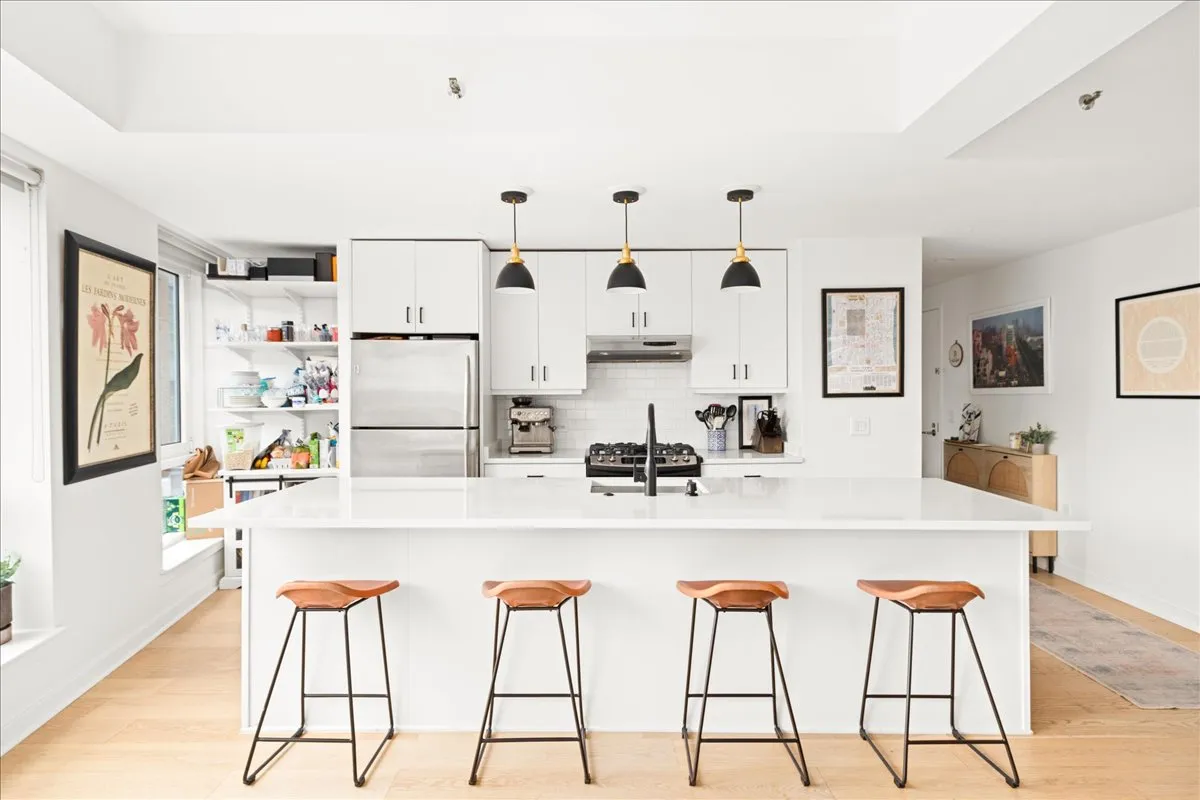 a kitchen with stainless steel appliances kitchen island granite countertop a table chairs and white cabinets