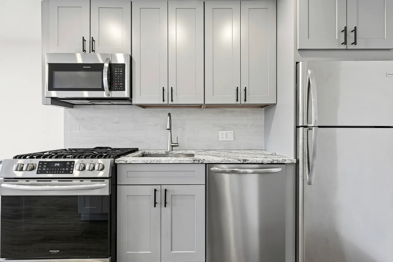 a kitchen with stainless steel appliances granite countertop a stove a refrigerator and a microwave