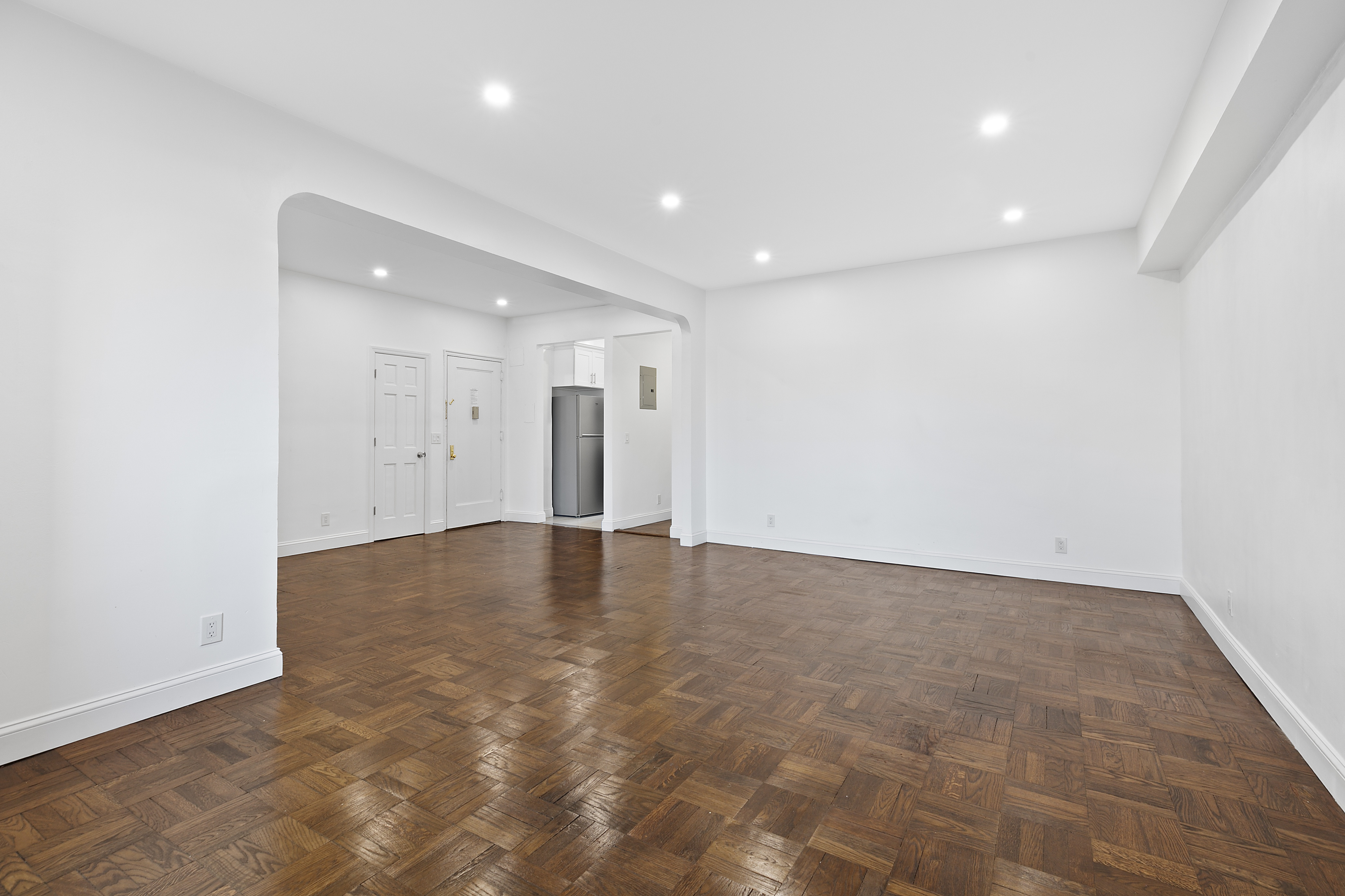 159-34 Riverside Drive West, Unit 1J90 Manhattan, NY 10032 - Photo 5 of 19 a view of an empty room with wooden floor