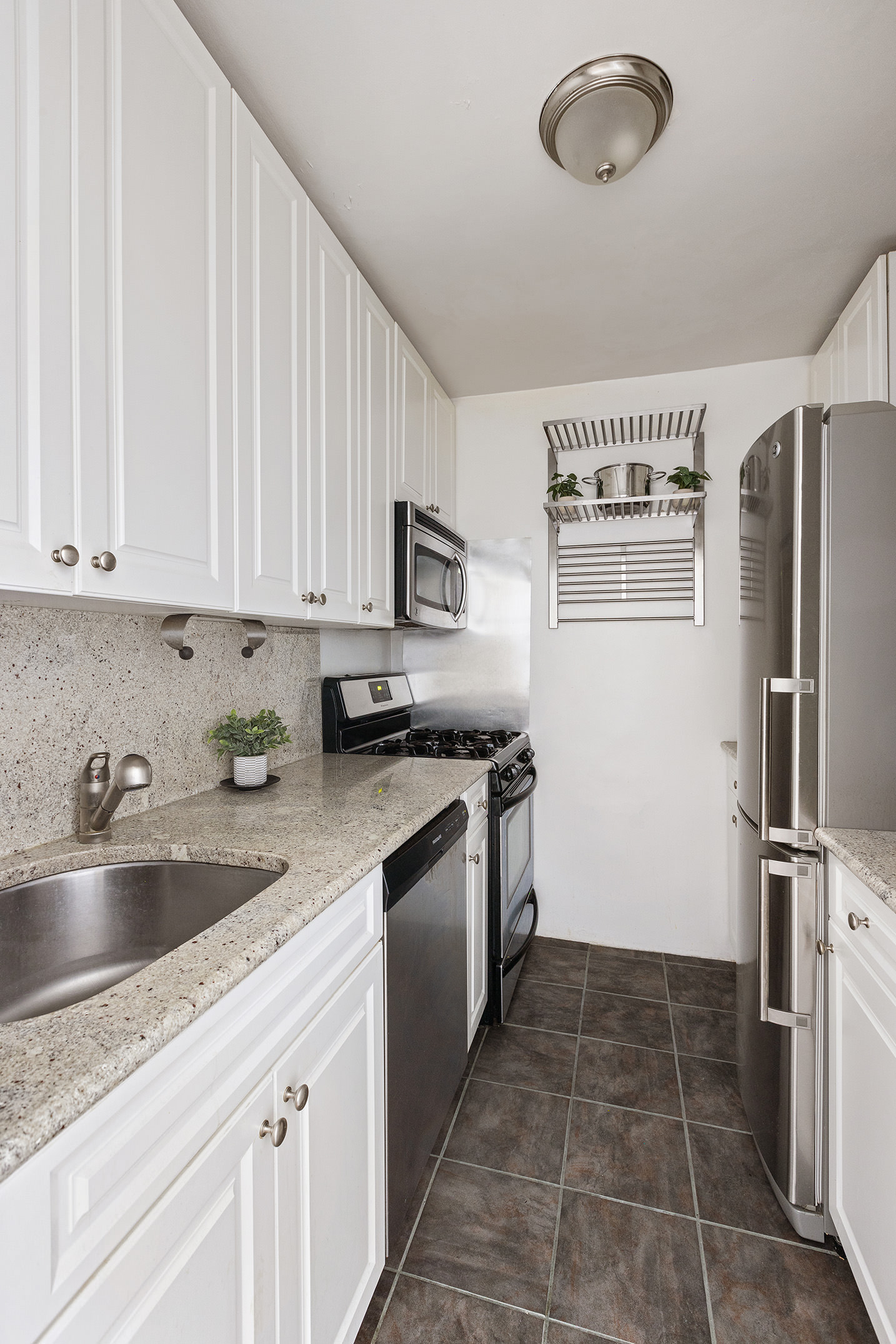 170 West End Avenue, Unit 12C Manhattan, NY 10023 - Photo 6 of 9 a kitchen with a refrigerator sink and cabinets