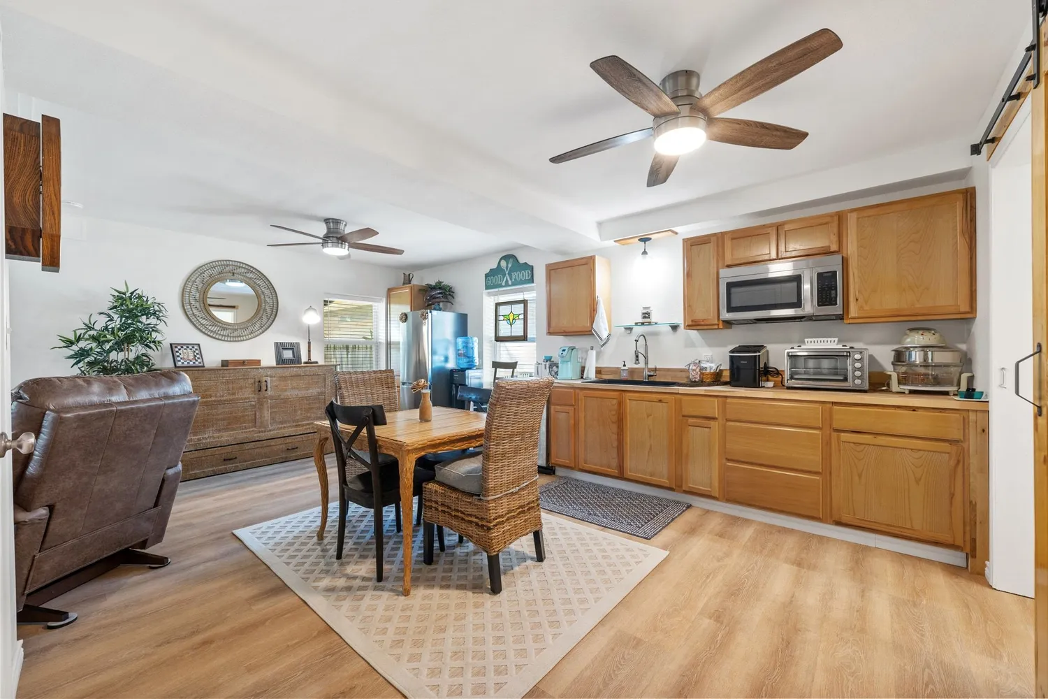 a kitchen with granite countertop cabinets stainless steel appliances dining table and a large window