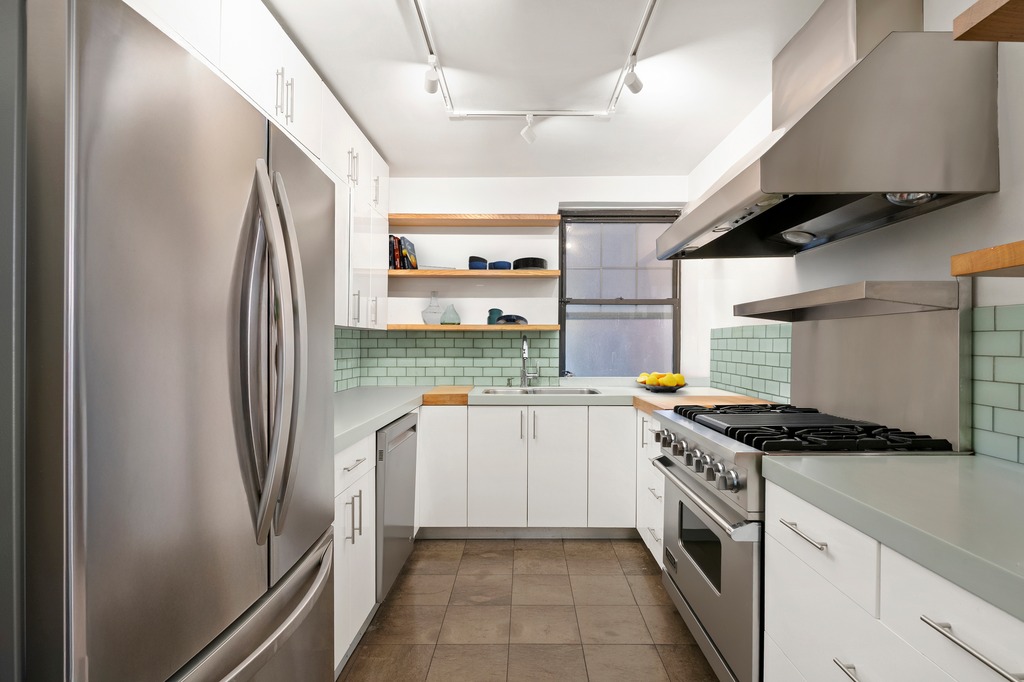 290 6th Avenue, Unit 2KL Manhattan, NY 10014 - Photo 6 of 18 a kitchen with stainless steel appliances granite countertop a sink a stove and a refrigerator