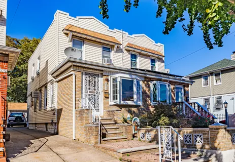 a front view of a house with a tree