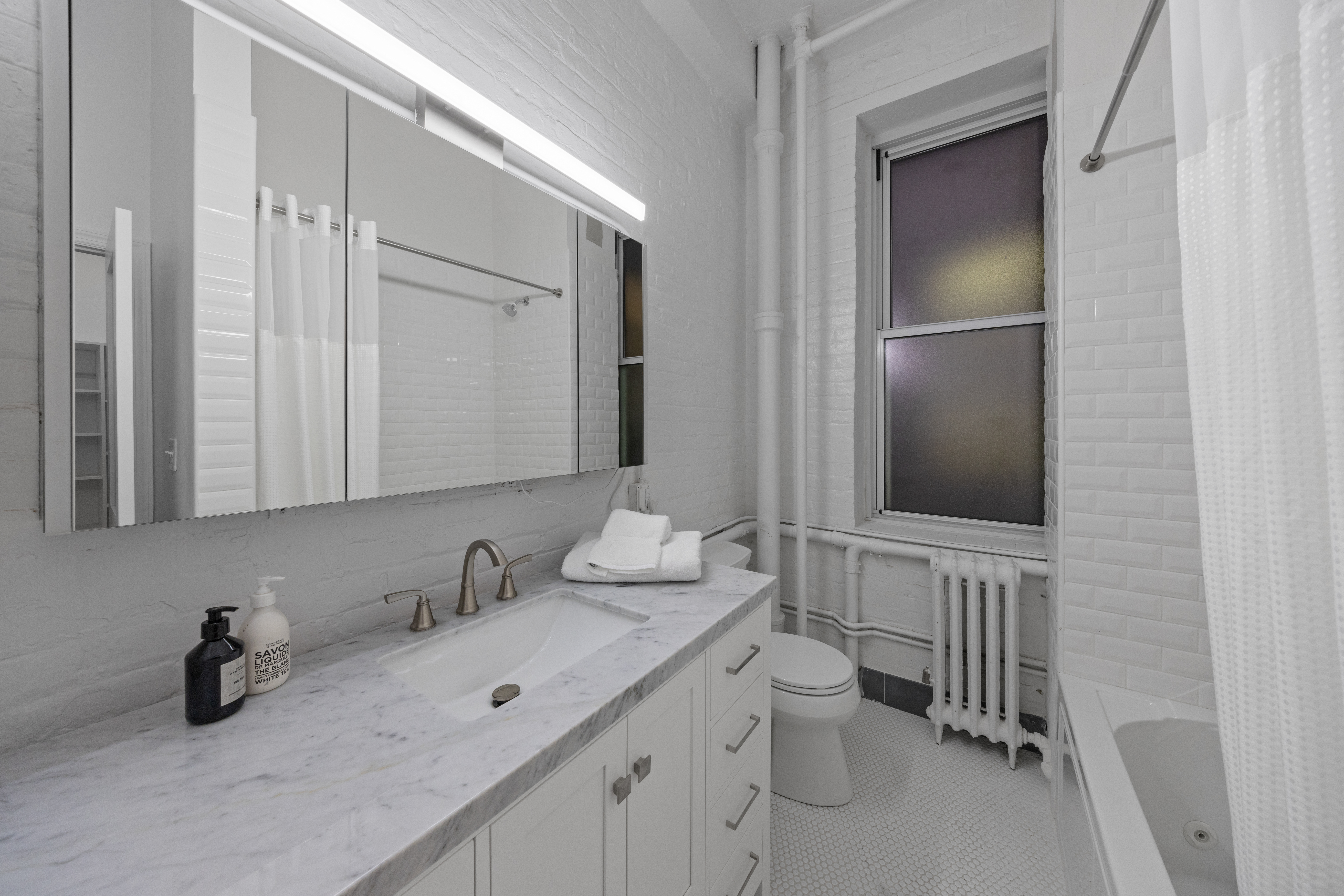95 Vandam Street, Unit 2R Manhattan, NY 10013 - Photo 13 of 21 a bathroom with a granite countertop sink toilet and mirror