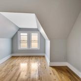 1617 Dorchester Road, Unit 3 Brooklyn, NY 11226 - Photo 4 of 6 an empty room with wooden floor and windows