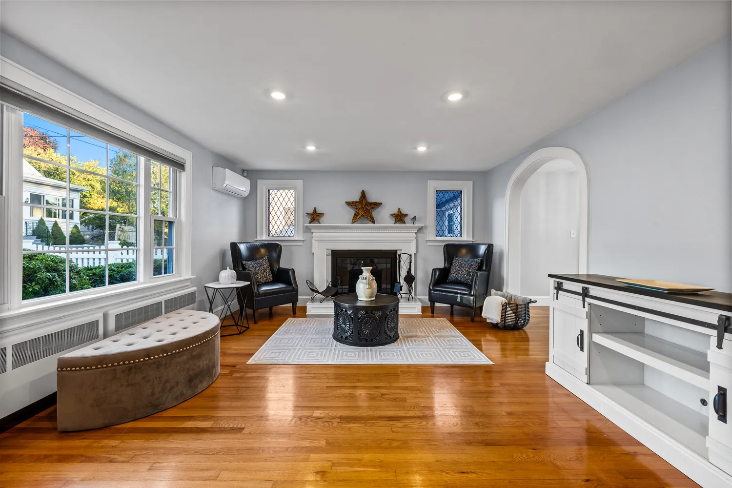 a living room with furniture a fireplace and large windows