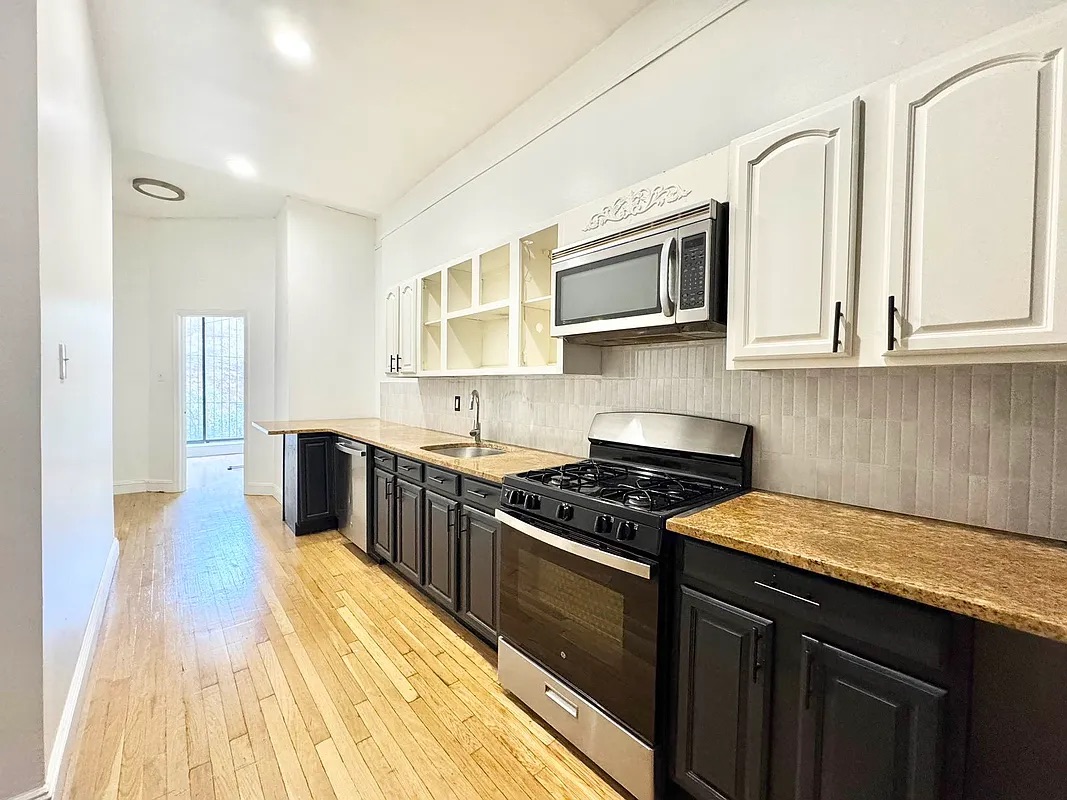 238 Gates Avenue, Unit 2 Brooklyn, NY 11238 - Photo 1 of 13 a kitchen with stainless steel appliances granite countertop a stove a sink and a microwave