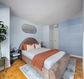 a bedroom with bed and a potted plant