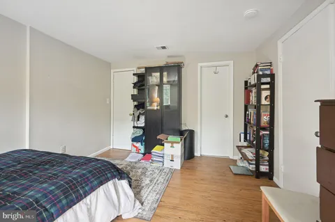 a bedroom with a bed and a wooden floor