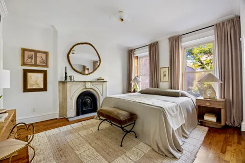 a bed sitting in a bedroom next to a window