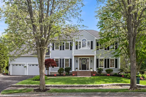 front view of a brick house with a yard