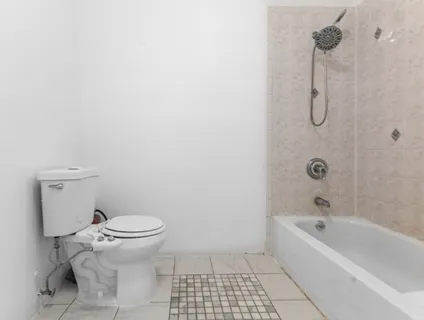 a bathroom with a granite countertop toilet and a bathtub