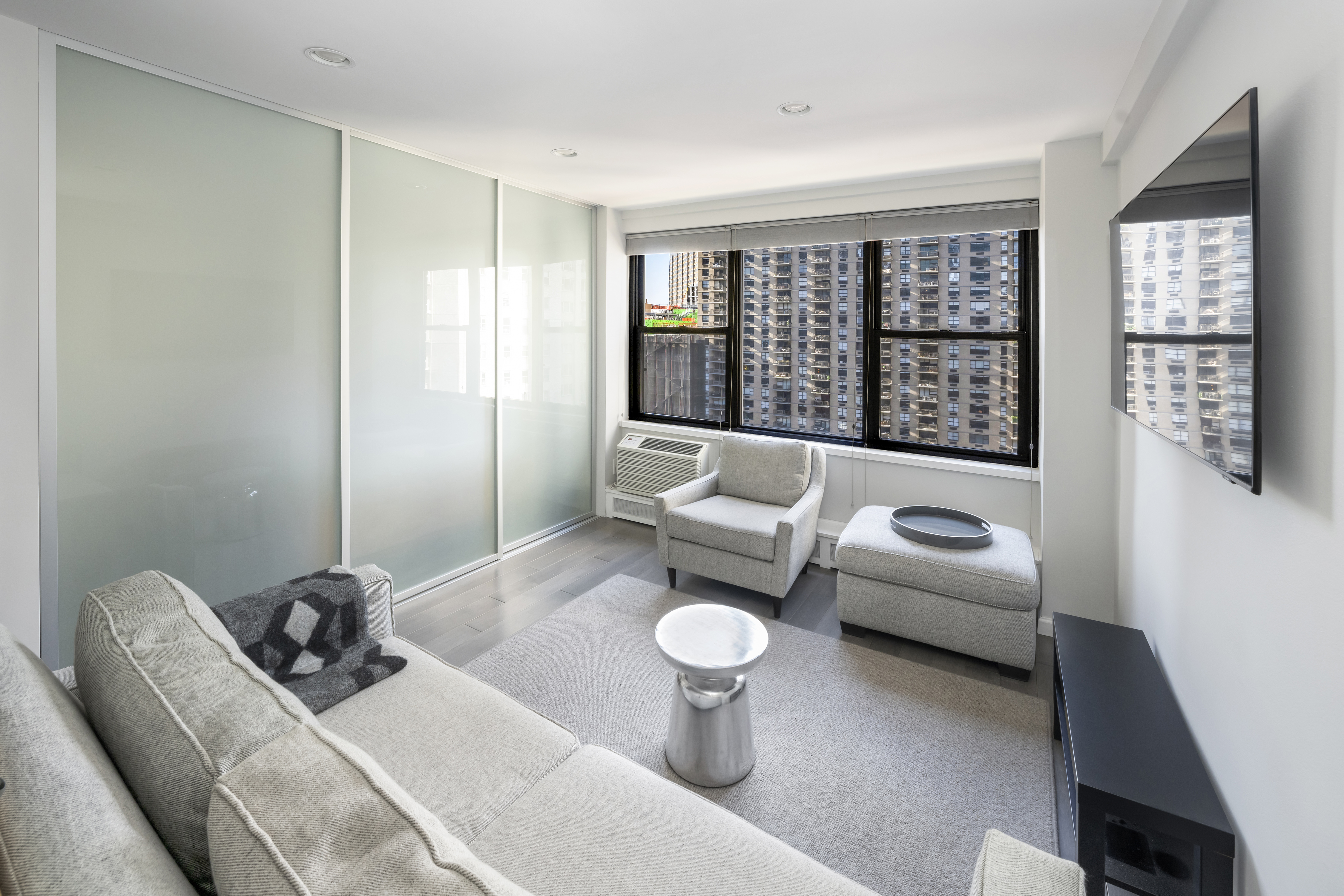 2 Tudor City Place, Unit 9OS Manhattan, NY 10017 - Photo 2 of 11 a living room with furniture and a window
