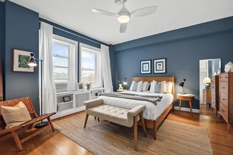 a bedroom with a bed a couch and a large window
