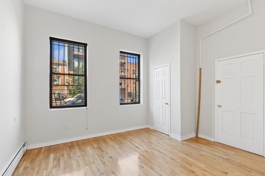 293 Tompkins Avenue Brooklyn, NY 11221 - Photo 5 of 19 a view of an empty room with wooden floor and a window