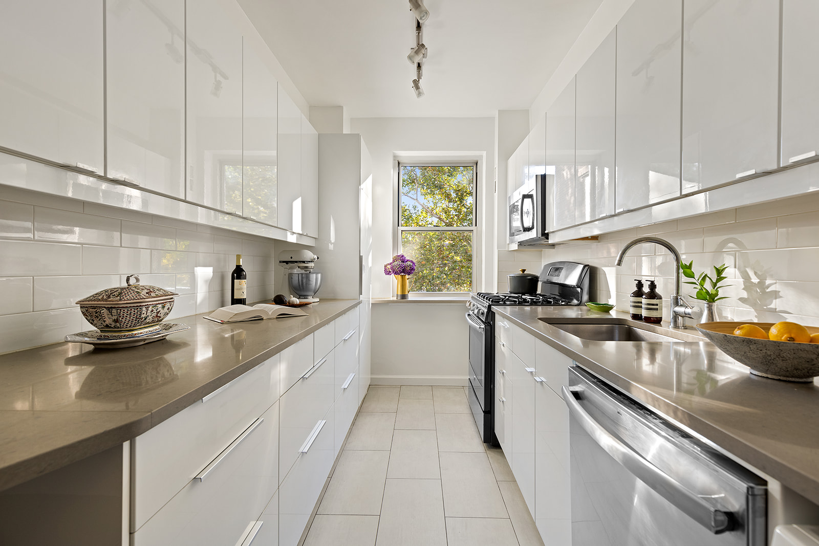 550 Grand Street, Unit G3E Manhattan, NY 10002 - Photo 3 of 7 a kitchen with stainless steel appliances granite countertop a sink stove and cabinets