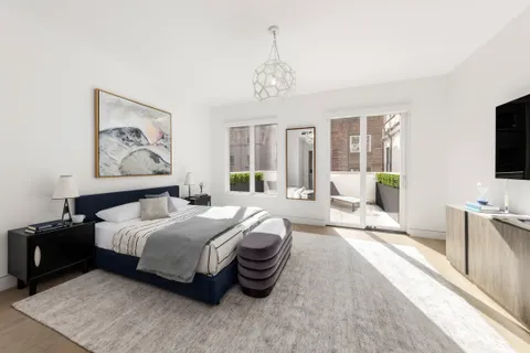 a spacious bedroom with a bed and a flat screen tv