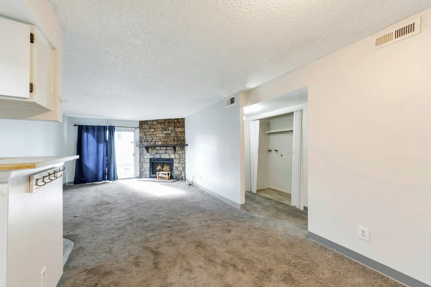 a view of an empty room with window and fireplace