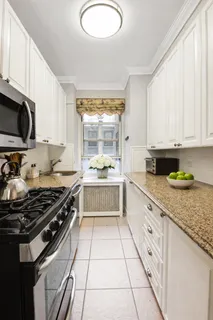 a kitchen with a stove a sink and a white cabinets