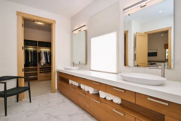 a spacious bathroom with a tub a double vanity sink a window and a shower