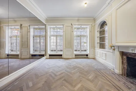 a view of an empty room with a fireplace and a window