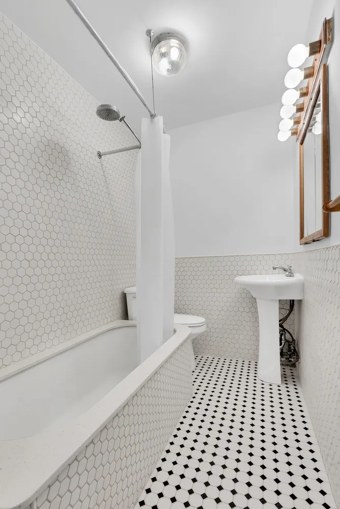 a bathroom with a sink a toilet a mirror and shower