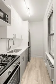 a kitchen with granite countertop a sink stove and refrigerator