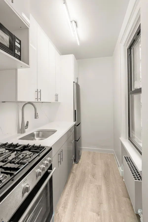 a kitchen with granite countertop a sink stove and refrigerator