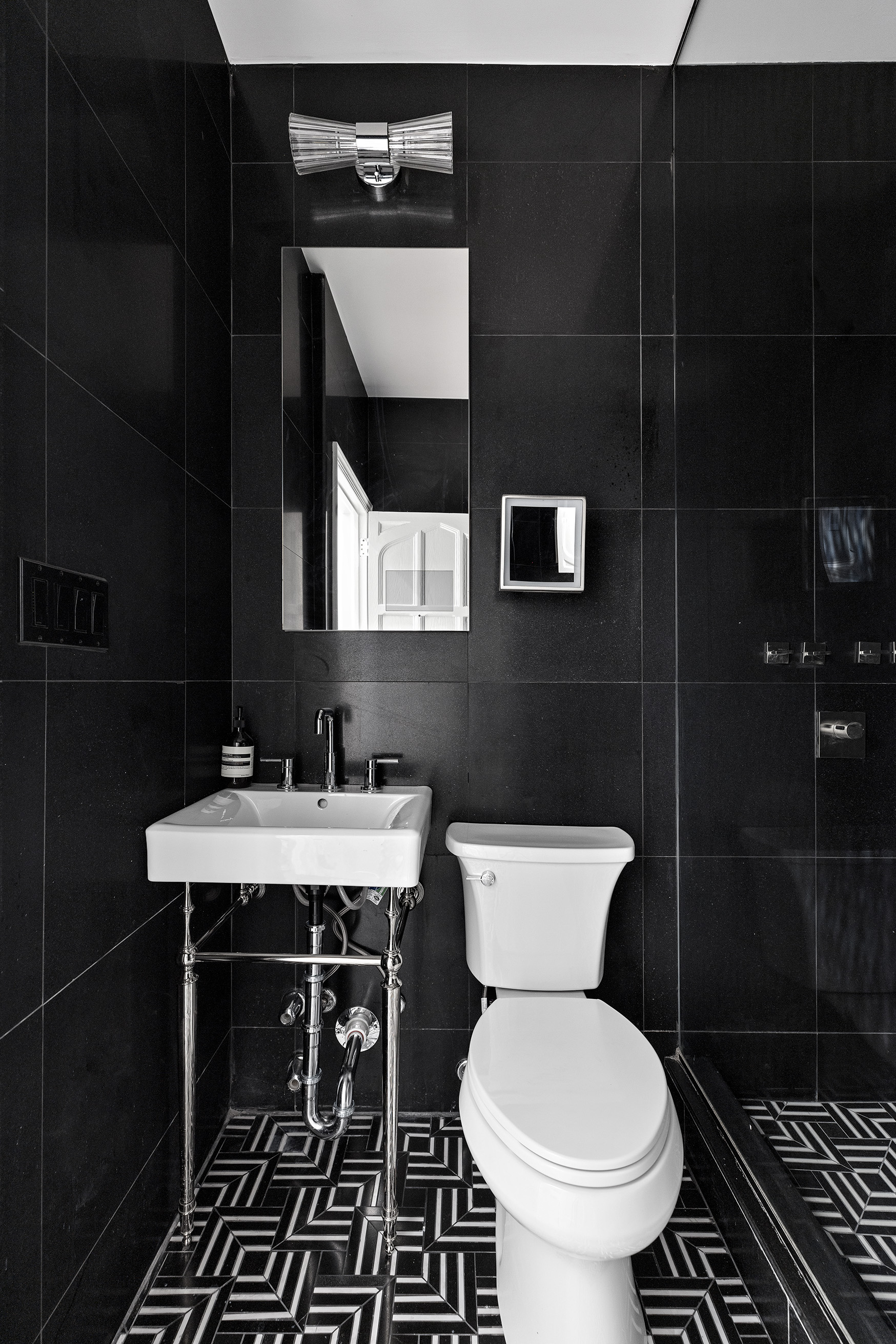 25 East 94th Street Manhattan, NY 10128 - Photo 28 of 33 a bathroom with a toilet a sink and mirror