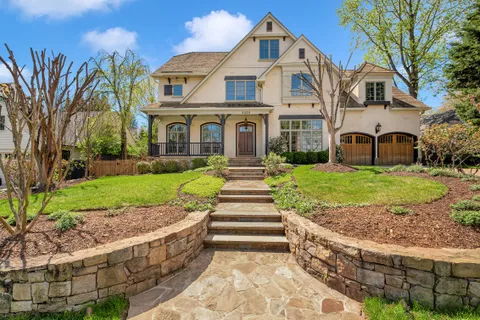 a front view of a house with a yard and potted plants