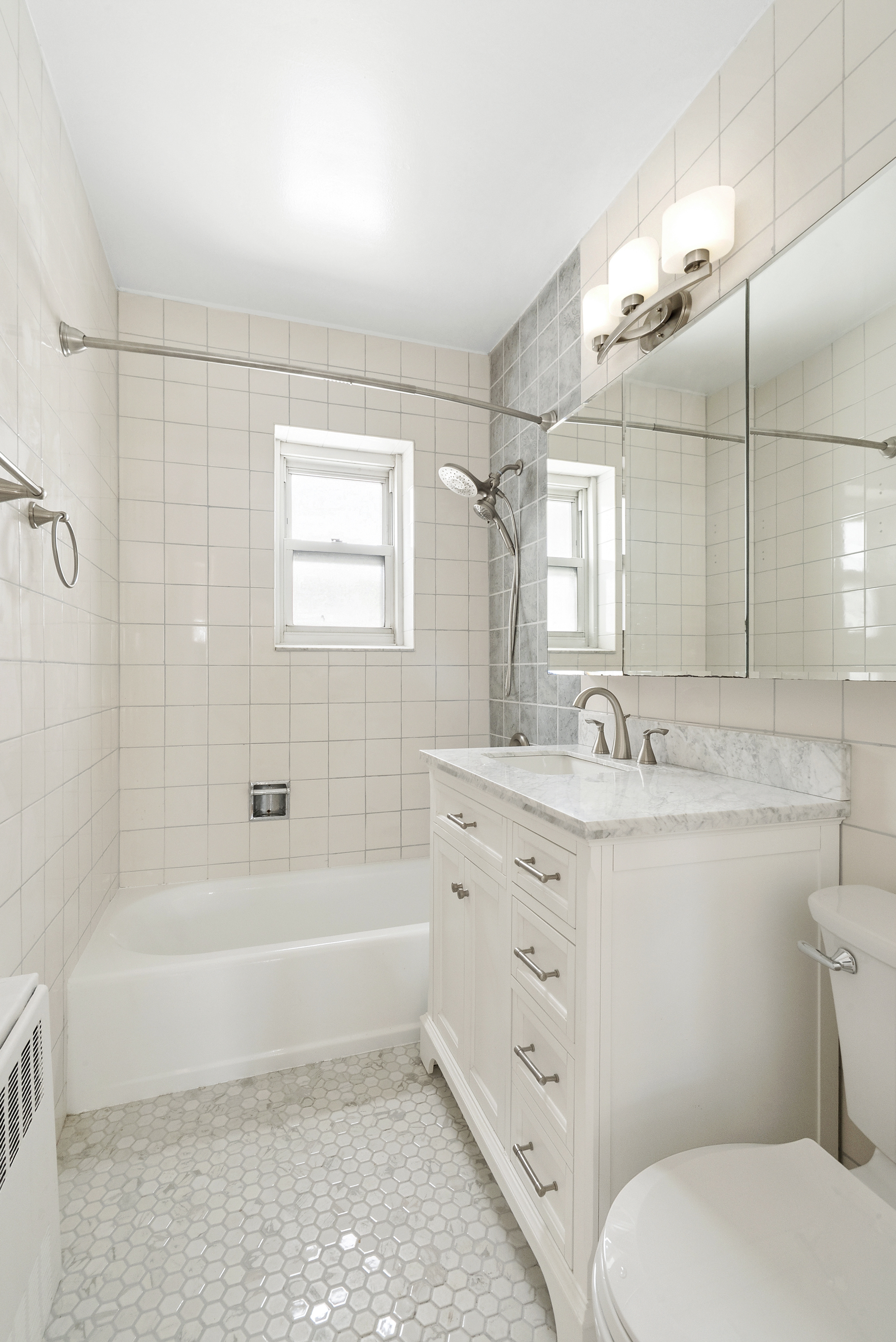 57 West 58th Street, Unit 10E Manhattan, NY 10019 - Photo 4 of 5 a bathroom with a granite countertop toilet a sink and bathtub
