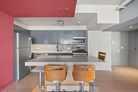 a kitchen with stainless steel appliances granite countertop a refrigerator and a stove top oven