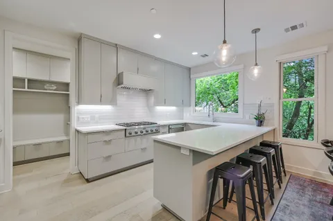 a kitchen with a stove a sink a center island and a window