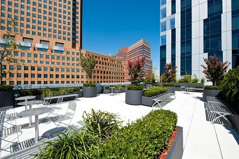 a view of a building with potted plants and a bench