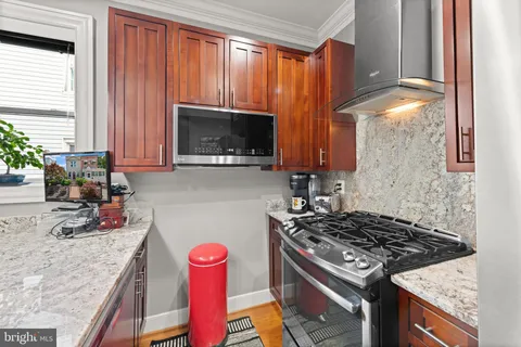 a kitchen with granite countertop a stove and a sink