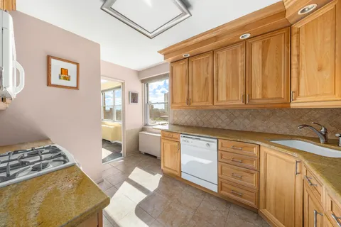 a kitchen with granite countertop a sink stove and cabinets