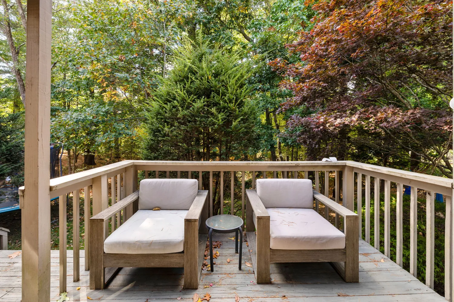 a balcony with wooden floor and furniture