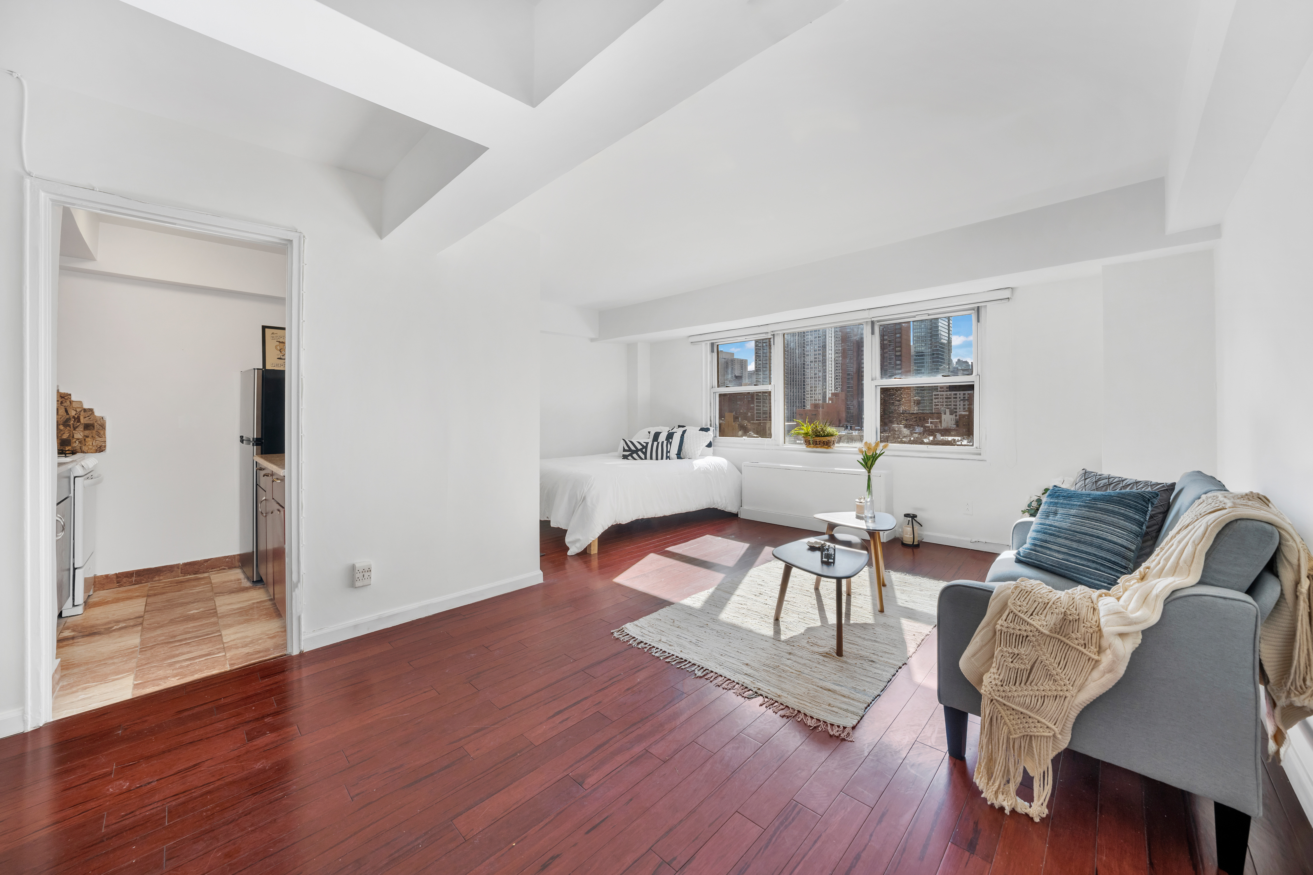 210 East 63rd Street, Unit 11F Manhattan, NY 10065 - Photo 4 of 14 a living room with furniture and wooden floor