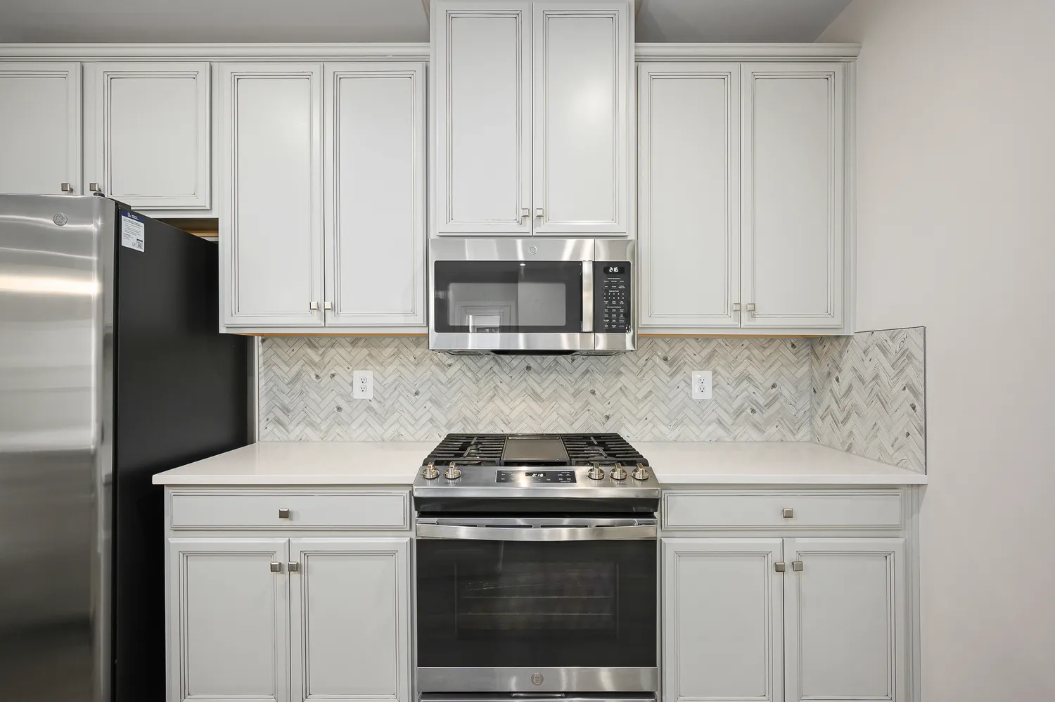 a kitchen with granite countertop white cabinets and stainless steel appliances