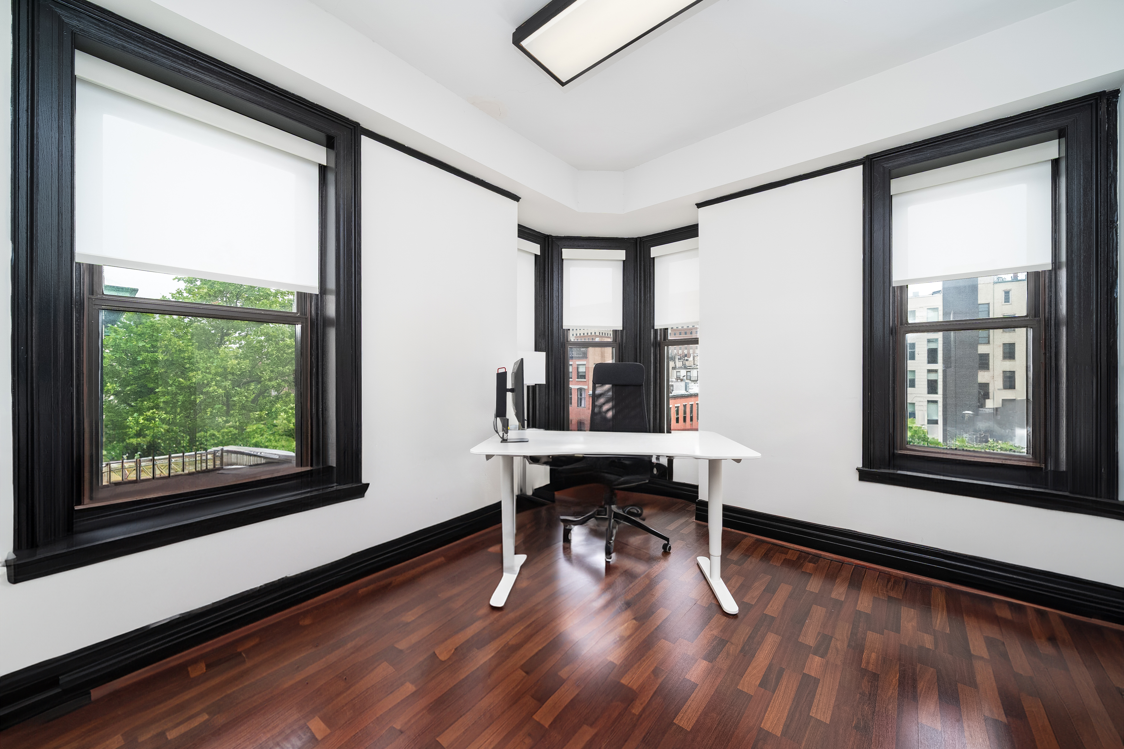 a view of a workspace with wooden floor and a window