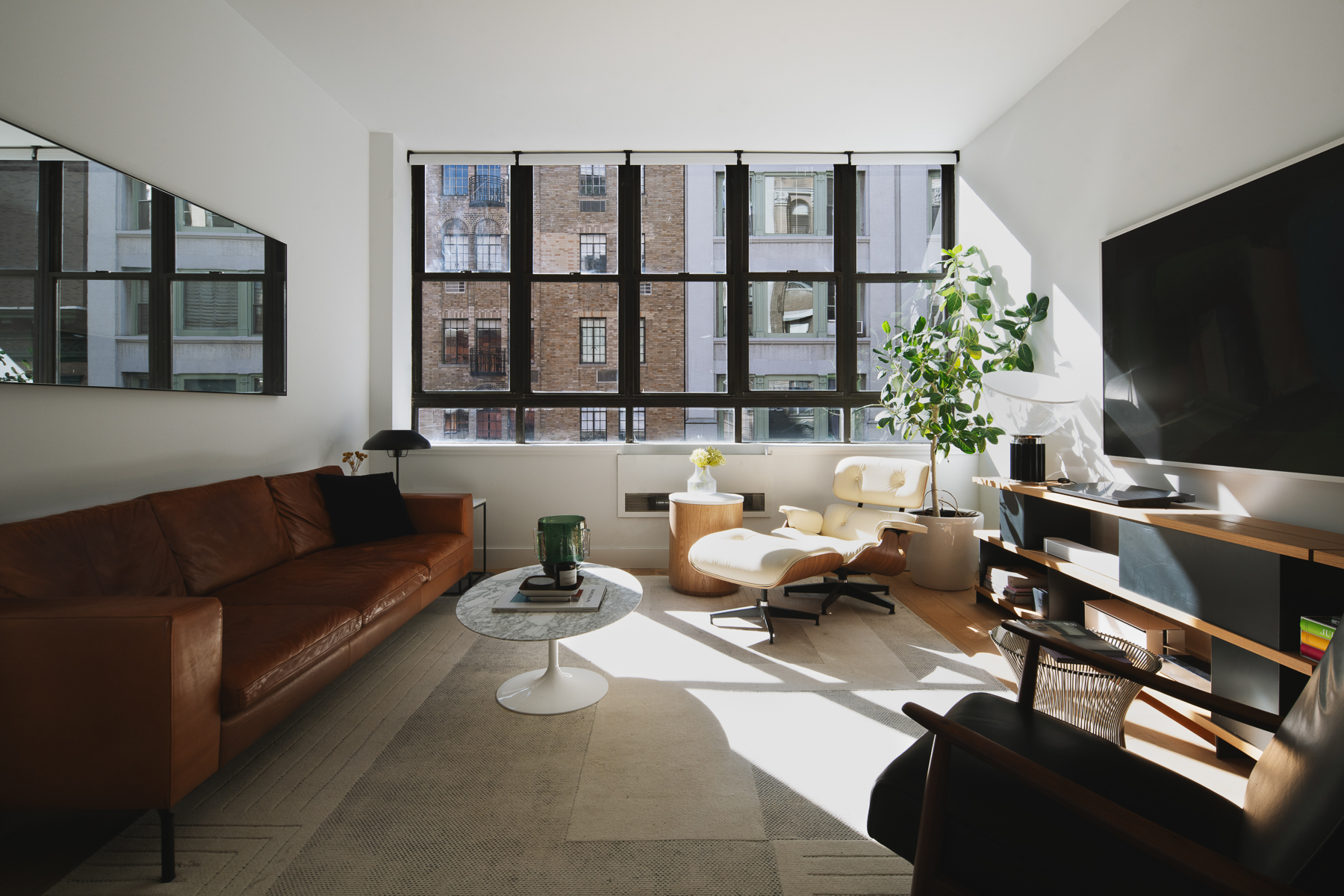 35 East 10th Street, Unit 4J Manhattan, NY 10003 - Photo 2 of 19 a living room with furniture and a flat screen tv