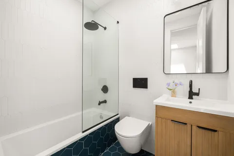 a bathroom with a sink toilet a mirror and shower