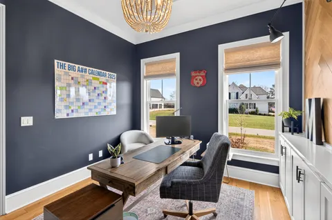 a living room with furniture a flat screen tv and a floor to ceiling window