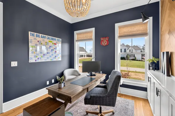 a living room with furniture a flat screen tv and a floor to ceiling window