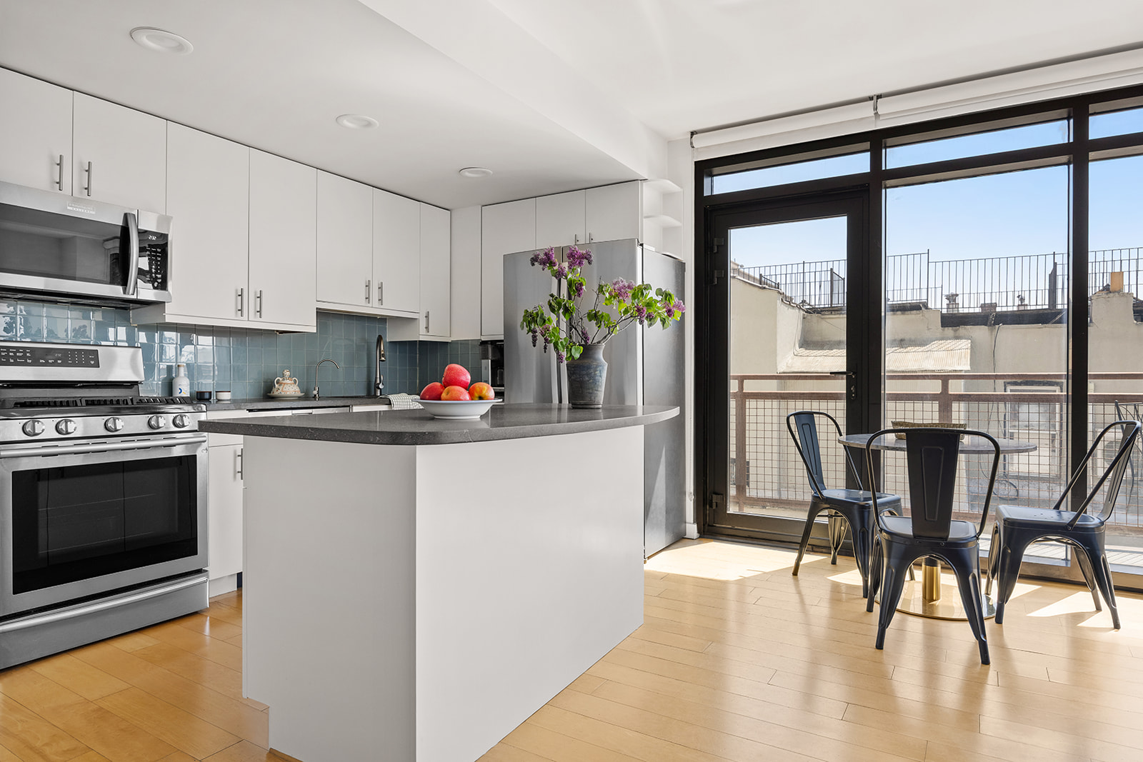 20 Tiffany Place, Unit 5S Brooklyn, NY 11231 - Photo 2 of 12 a kitchen with stainless steel appliances granite countertop a stove top oven a sink a dining table and chairs with wooden floor