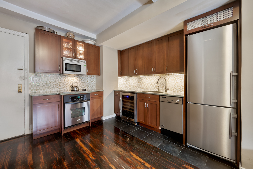 45 Tudor City Place, Unit 615 Manhattan, NY 10017 - Photo 2 of 5 a kitchen with granite countertop a refrigerator stove and sink