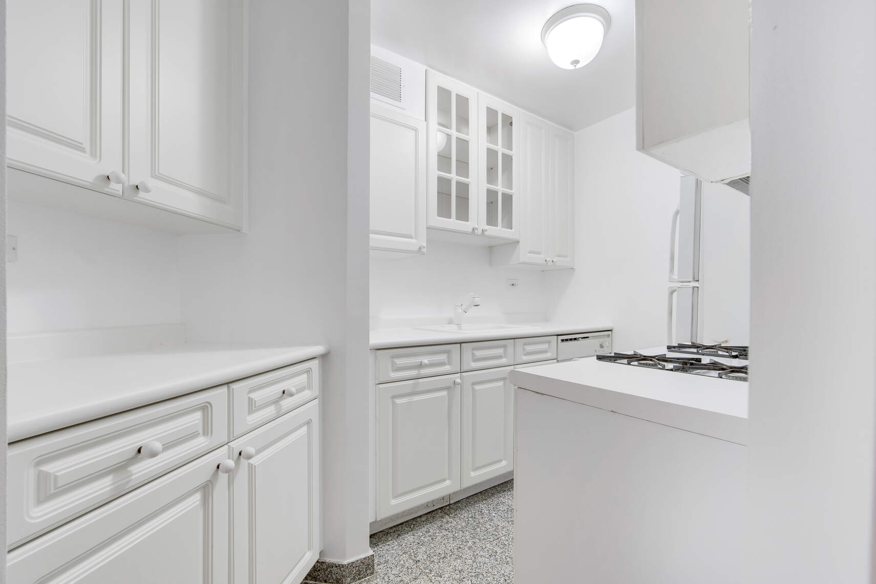 420 East 64th Street, Unit W4A Manhattan, NY 10065 - Photo 3 of 5 a kitchen with white cabinets and white appliances
