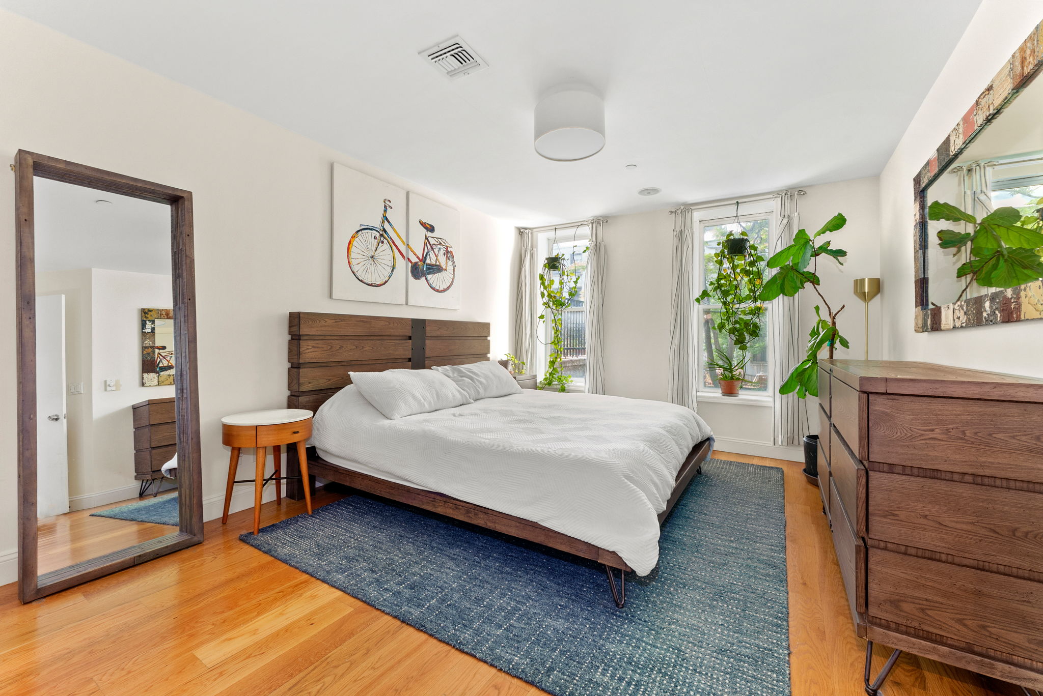 54 State Street, Unit 5 Brooklyn, NY 11201 - Photo 5 of 9 a bedroom with a bed and a window with potted plants