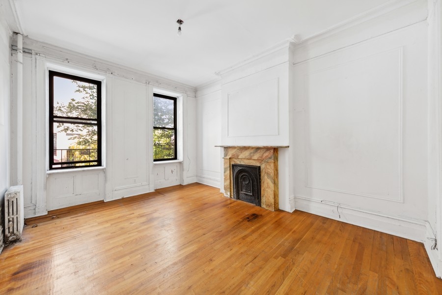 206 East 90th Street, Unit 2E Manhattan, NY 10128 - Photo 3 of 13 an empty room with windows and fireplace